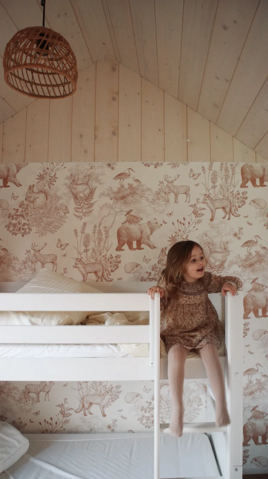 Kind op het stapelbed in de kinderkamer van tiny house Hjort