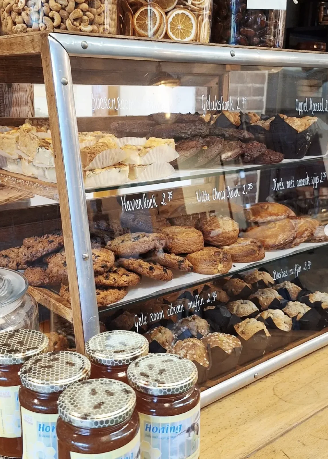 Vitrine met koeken, muffins en potten honing bij Jobse & Jobse in Heerde